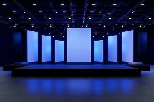 Blue illuminated corporate event stage with presentation screens