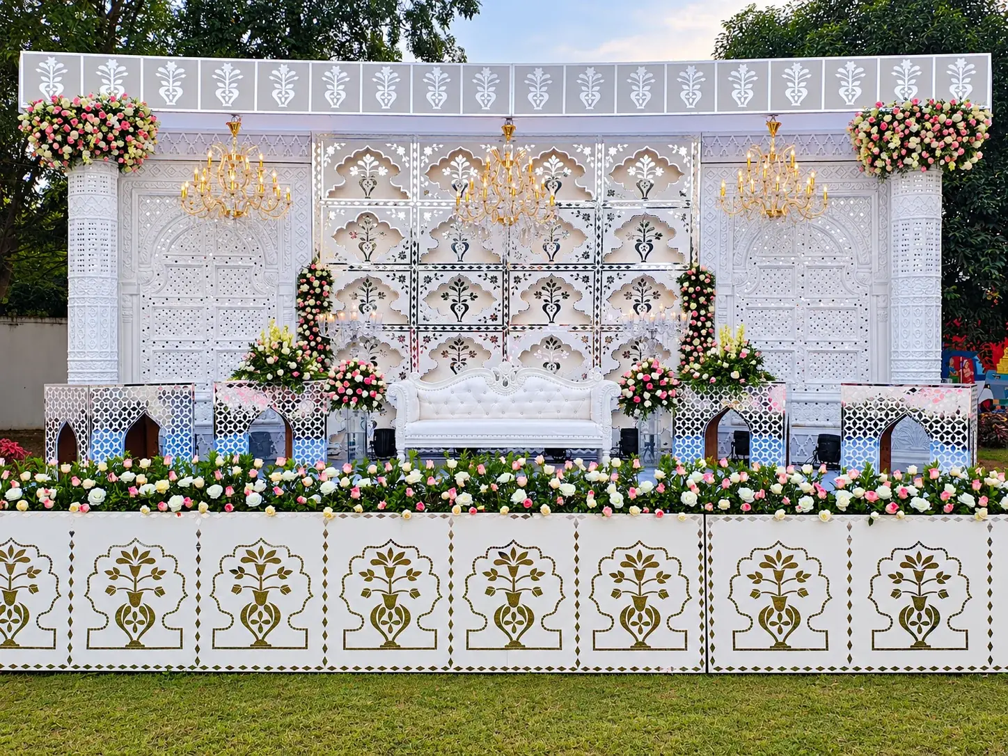 White reception stage with chandeliers and mirrored surfaces