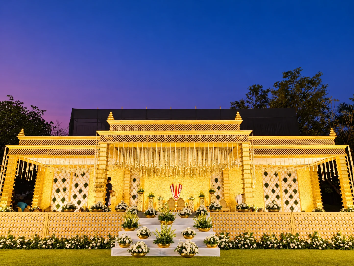 Golden gopuram mandap with a sacred floral motif at blue hour