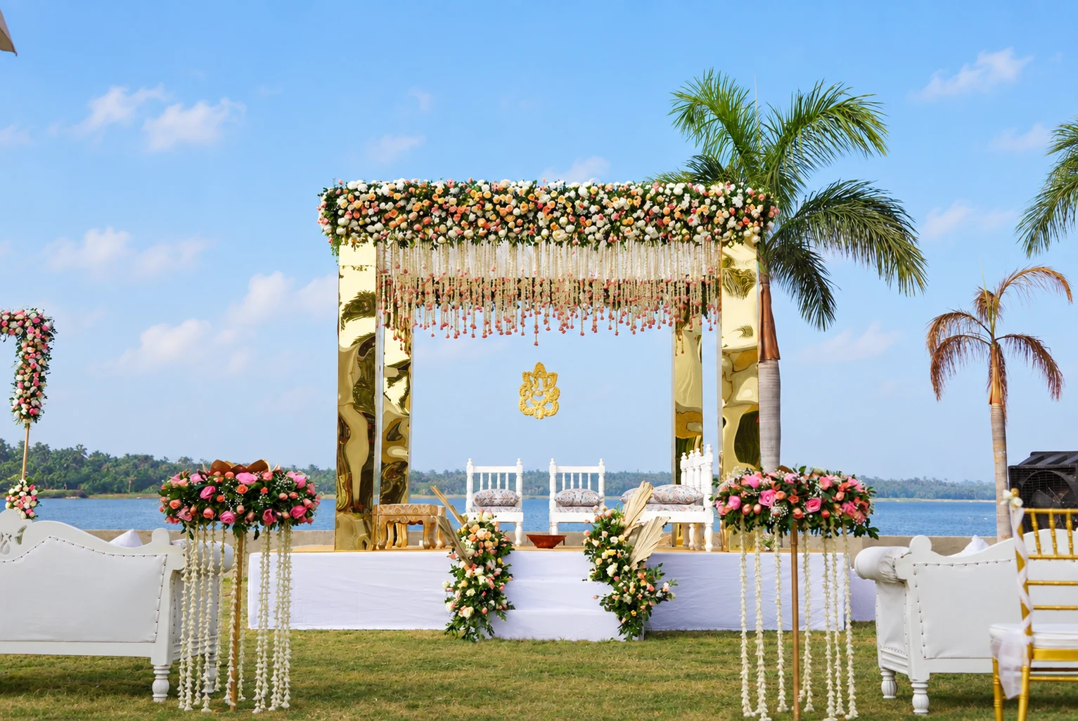 Gold and pink floral wedding mandap beside the water