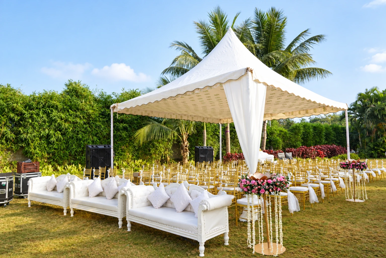 White garden canopy with gold chairs and floral aisle arrangements